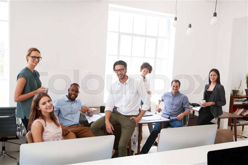 Relaxed business colleagues in their office smile to camera, stock photo