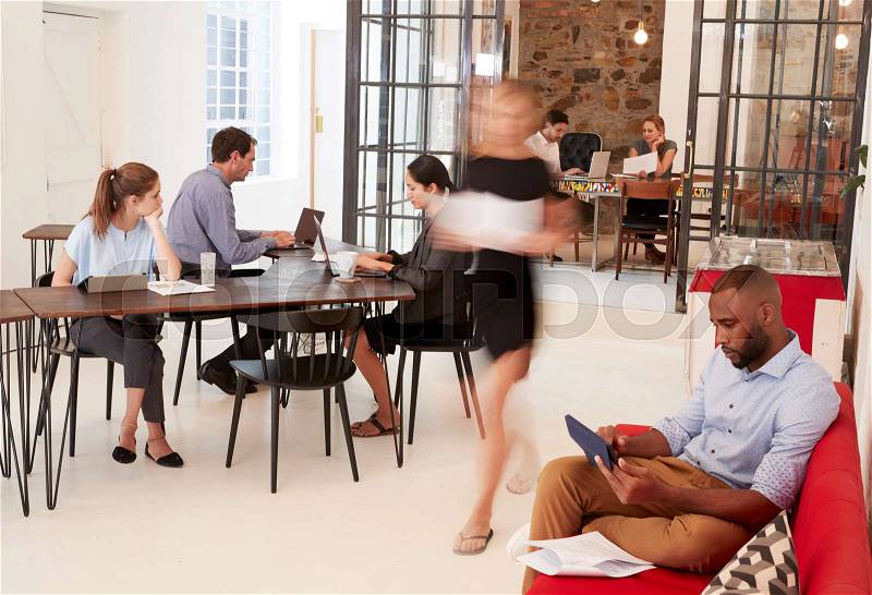 Young professionals working in a busy open plan office, stock photo