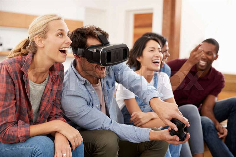 Friends Playing Computer Game With Virtual Reality Headset, stock photo