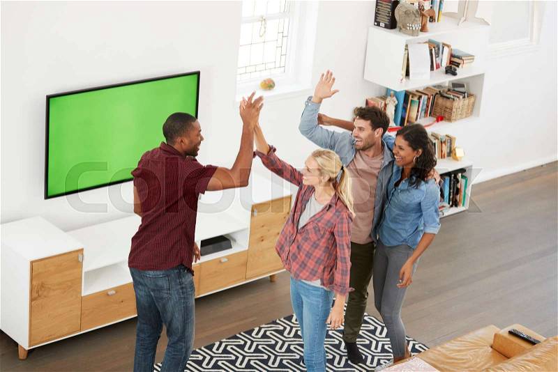 Group Of Young Friends Watching Sports On Television And Cheering, stock photo