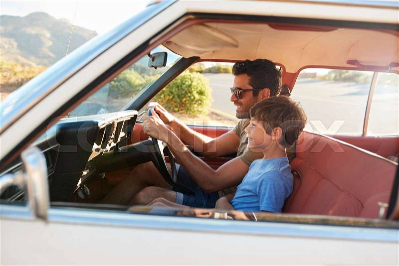 Father And Son In Front Seat Of Car On Road Trip, stock photo