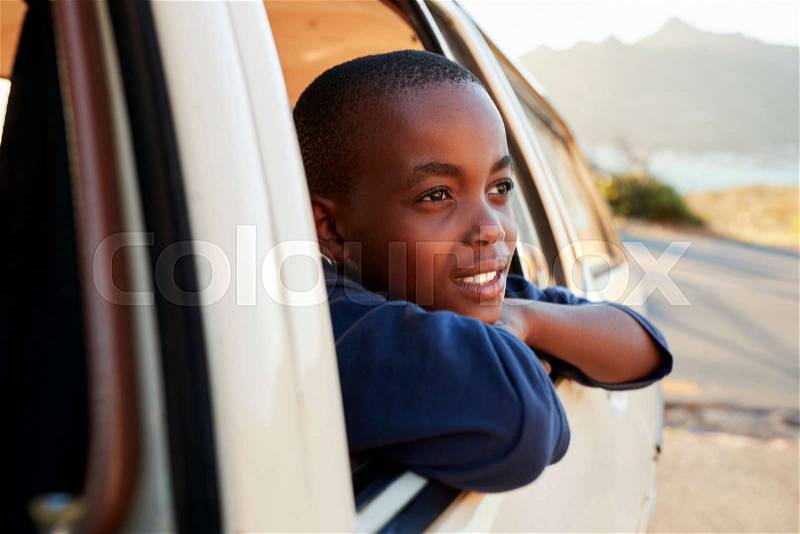 Boy Looking Out Of Car Window On Family Road Trip, stock photo
