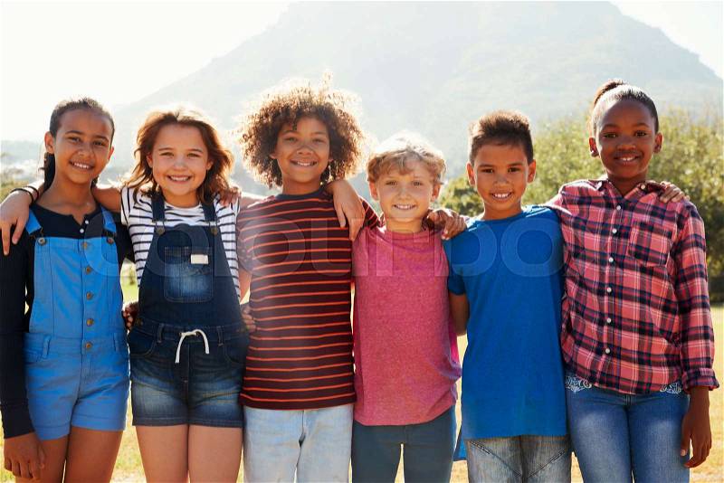 Three quarter length portrait of pre-teen friends in a park, stock photo
