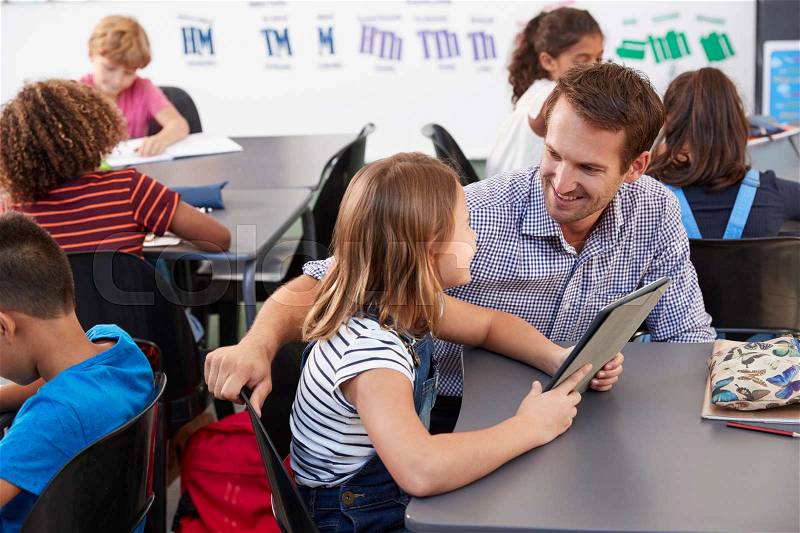 Teacher and schoolgirl with tablet computer looking at each other, stock photo
