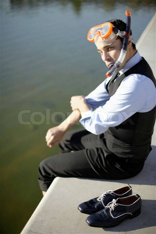 Business man in mask & snorkel by river, stock photo