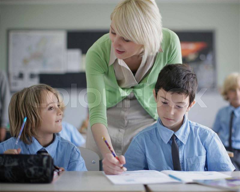 Female teacher correcting student work, stock photo