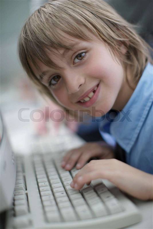 School boy using keyboard, stock photo