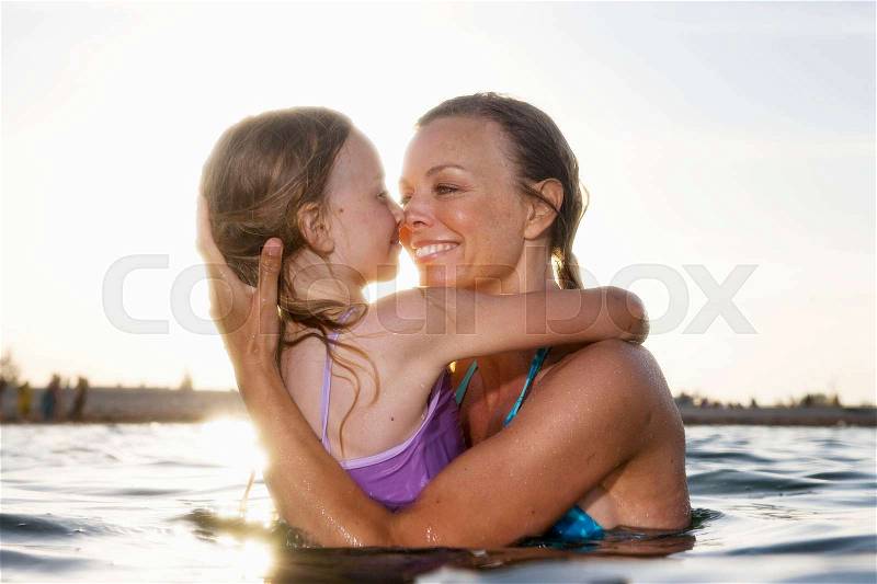Mother kissing daughter, stock photo