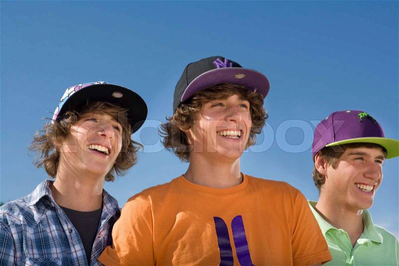 Teen boys wear baseball hat smiling, stock photo