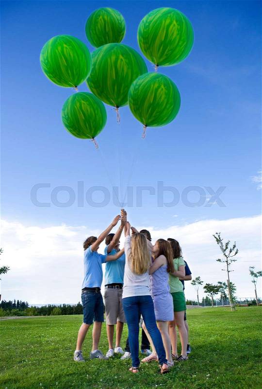 Teenagers holding helium green balloons, stock photo