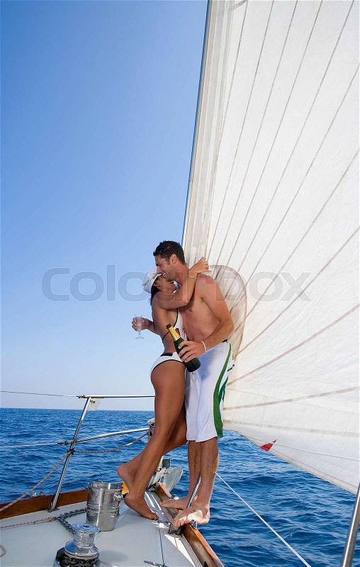 Couple on sailboat, with champagne, stock photo