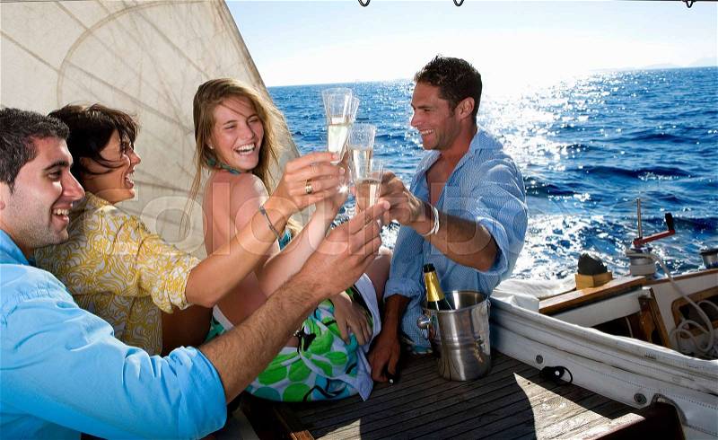 Two couples making a toast on sailboat, stock photo