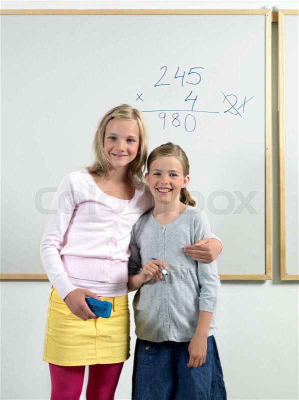 Two girls by whiteboard, stock photo