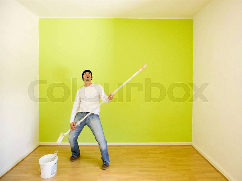 Man rocking while painting a room, stock photo