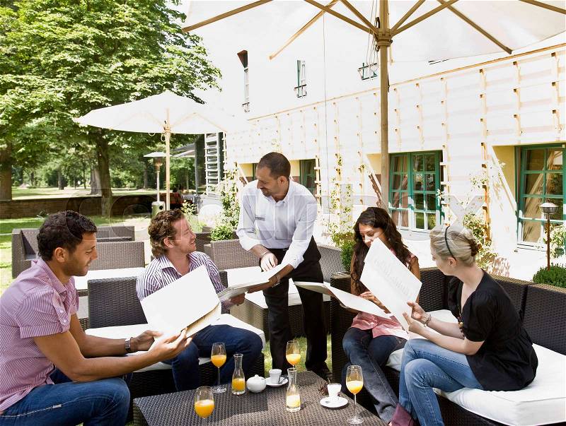 Men and women talking over menus, stock photo