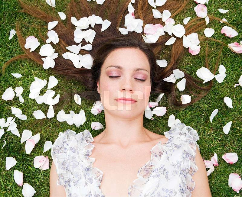 Woman sleeping, with rose pedals, stock photo
