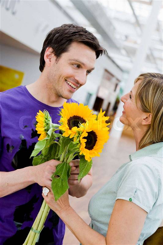 Man giving flowers to a woman, stock photo
