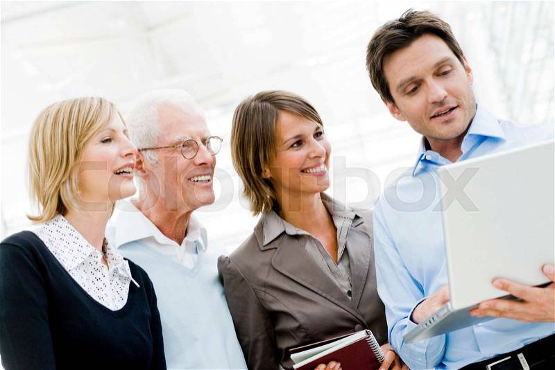 4 people looking at laptop, stock photo