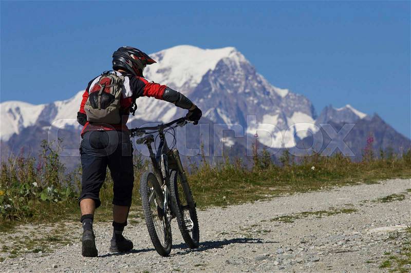 Mountain biker pushing his bike, stock photo
