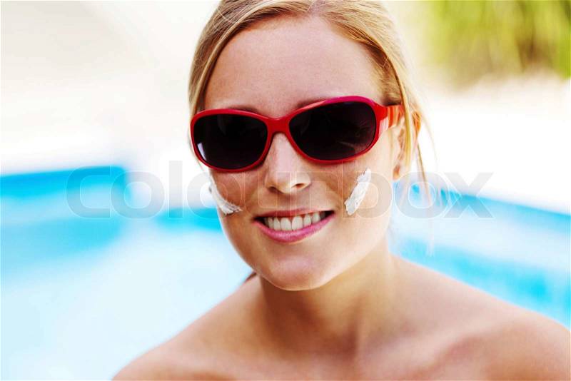 Young woman with sunglasses in the summer and sun cream, stock photo