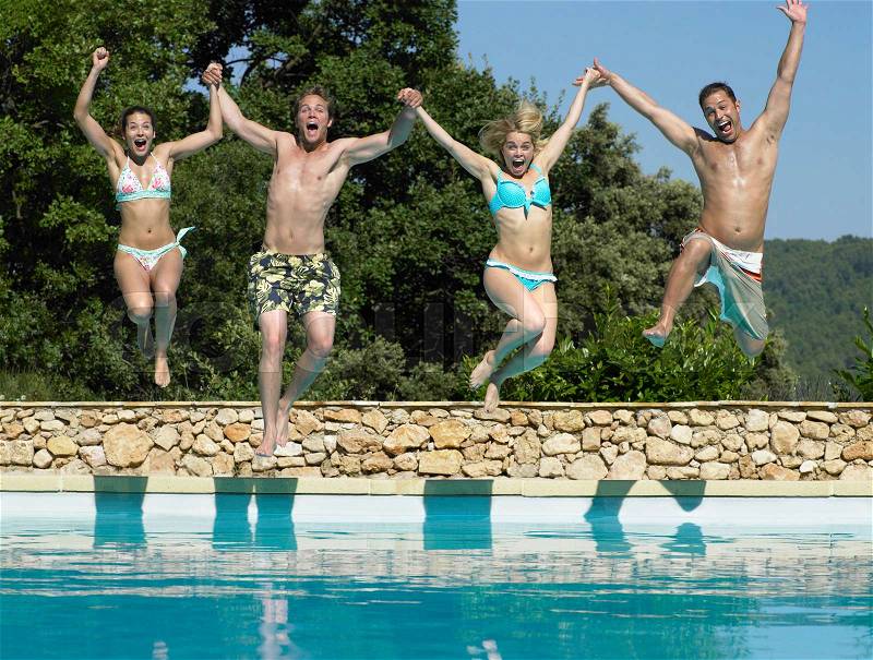 Friends jumping into pool, stock photo