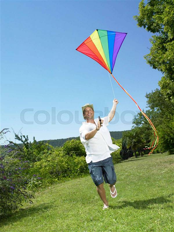 Man running with kite, stock photo