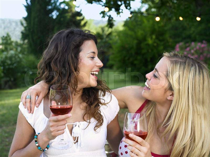 Two women laughing at barbecue, stock photo