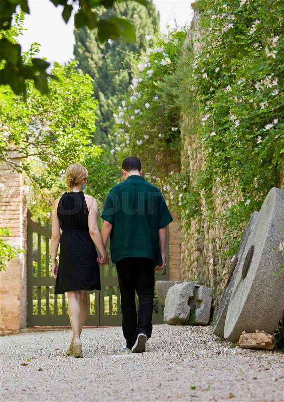 Man and woman walking and holding hands, stock photo