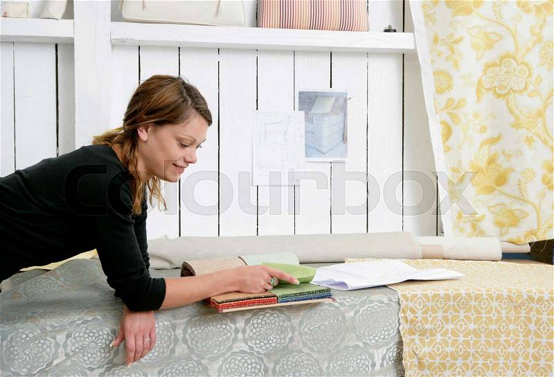 Woman choosing fabrics, stock photo
