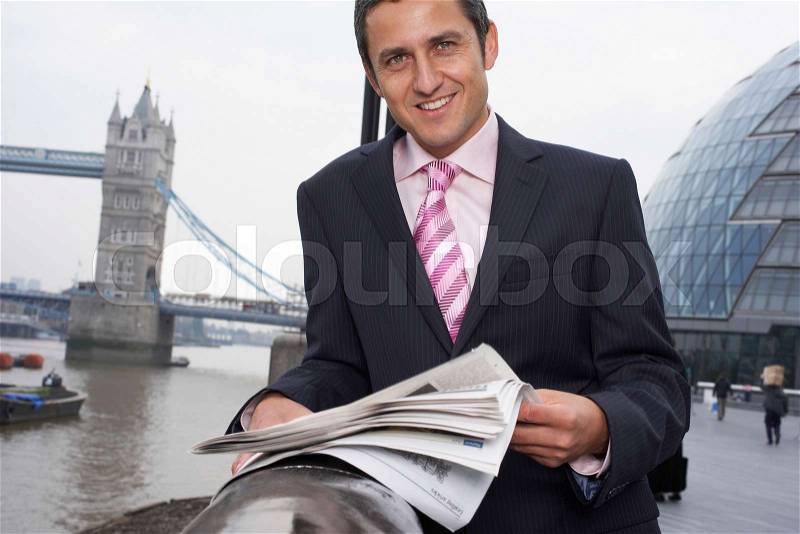 Business man reading newspaper outside, stock photo