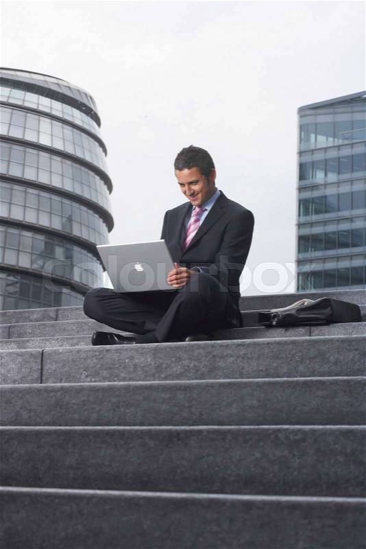 Business man with laptop outside, stock photo