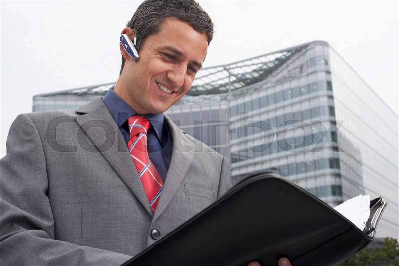 Man with bluetooth headset outside, stock photo