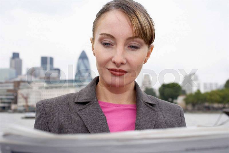 Business woman reading newspaper outside, stock photo