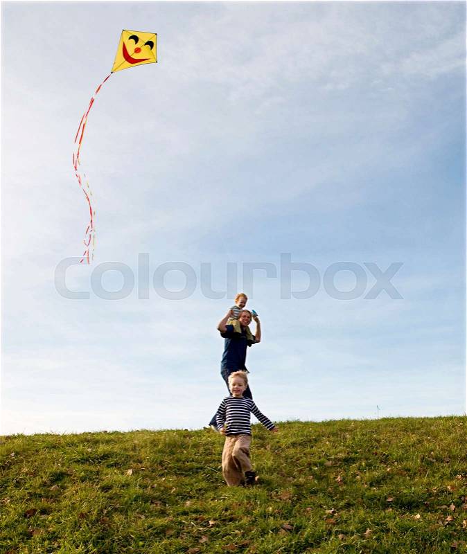 Two Boys and father fly a Kite, stock photo