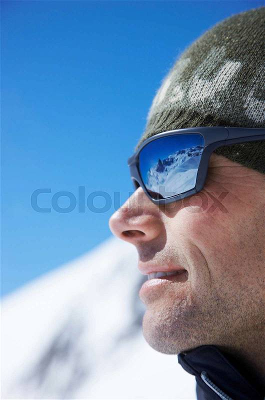 Man wearing sunglasses on mountain, stock photo