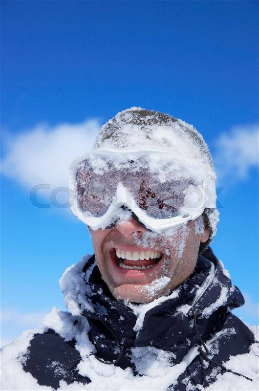 Man laughing, face covered with snow, stock photo