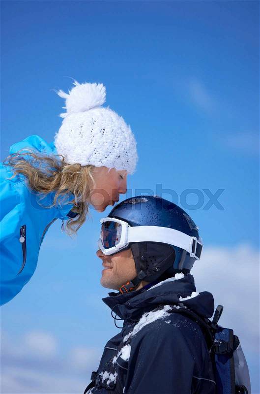 Couple sitting close in chair lift, stock photo