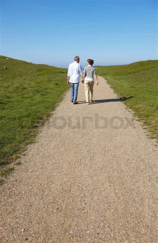 Mature couple walking away together, stock photo