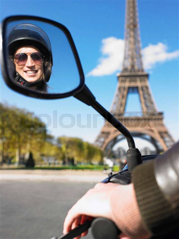 Woman on moped in Paris, stock photo