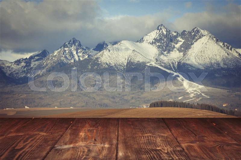 Table on winter mountains background, stock photo