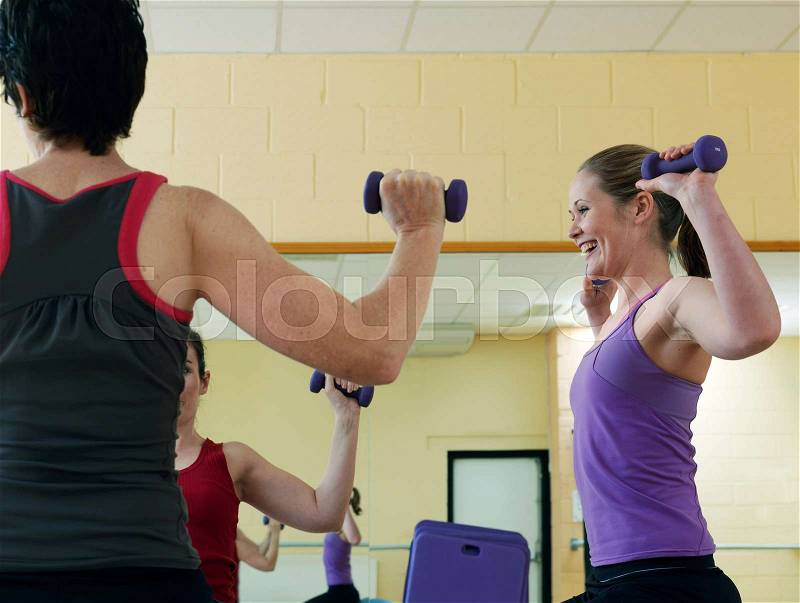 Women exercising with weights at gym, stock photo