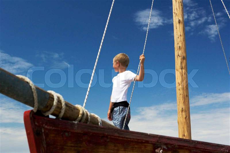 Boy on sailing boat, stock photo