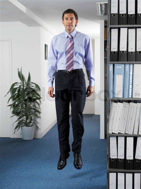 Office worker jumping in office, stock photo