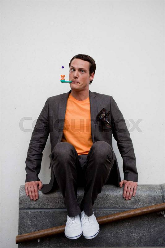 Man playing with toy pipe, stock photo