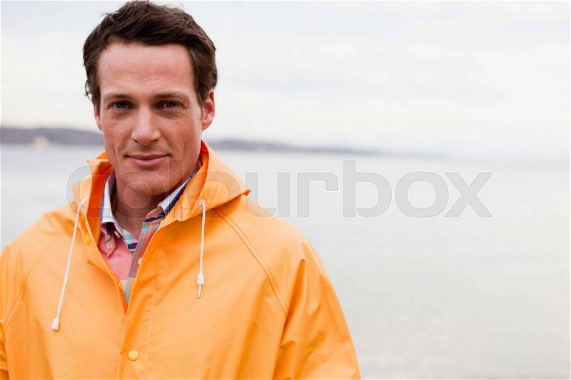 Man in raincoat looking at viewer, stock photo
