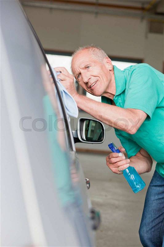 Old man washing car, stock photo