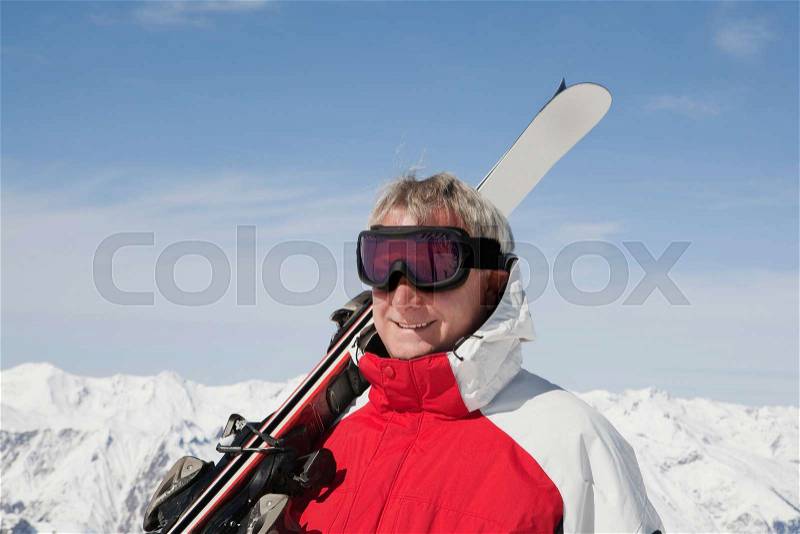 Mature man holding ski\'s, stock photo