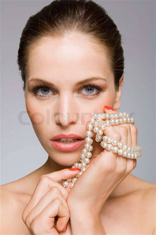Female beauty model with pearls in hand, stock photo