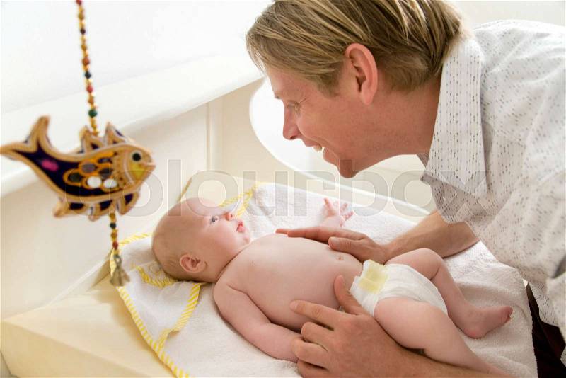 Father changing baby\'s nappy, stock photo
