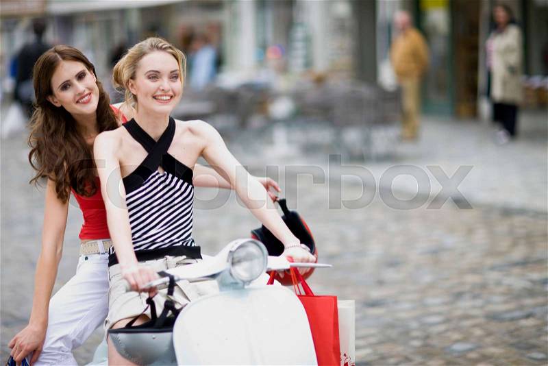 Girlfriends on a motor scooter, stock photo